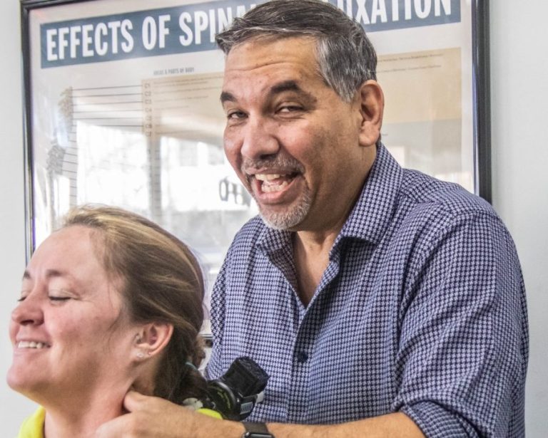 Danny DeReuter smiling while working with someone at The Natural Life